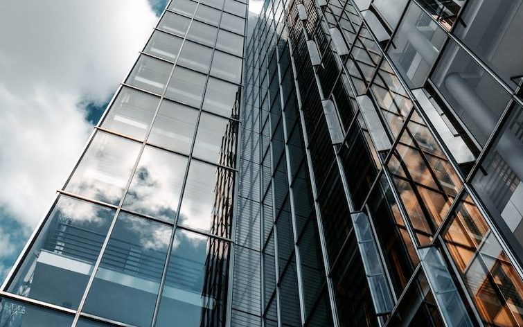 low angle photography of glass building under cloudy sky